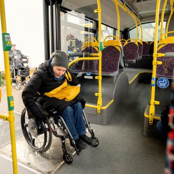 Eine Person im Rollstuhl nutzt die Rampe, um in einen Bus der BVG einzusteigen