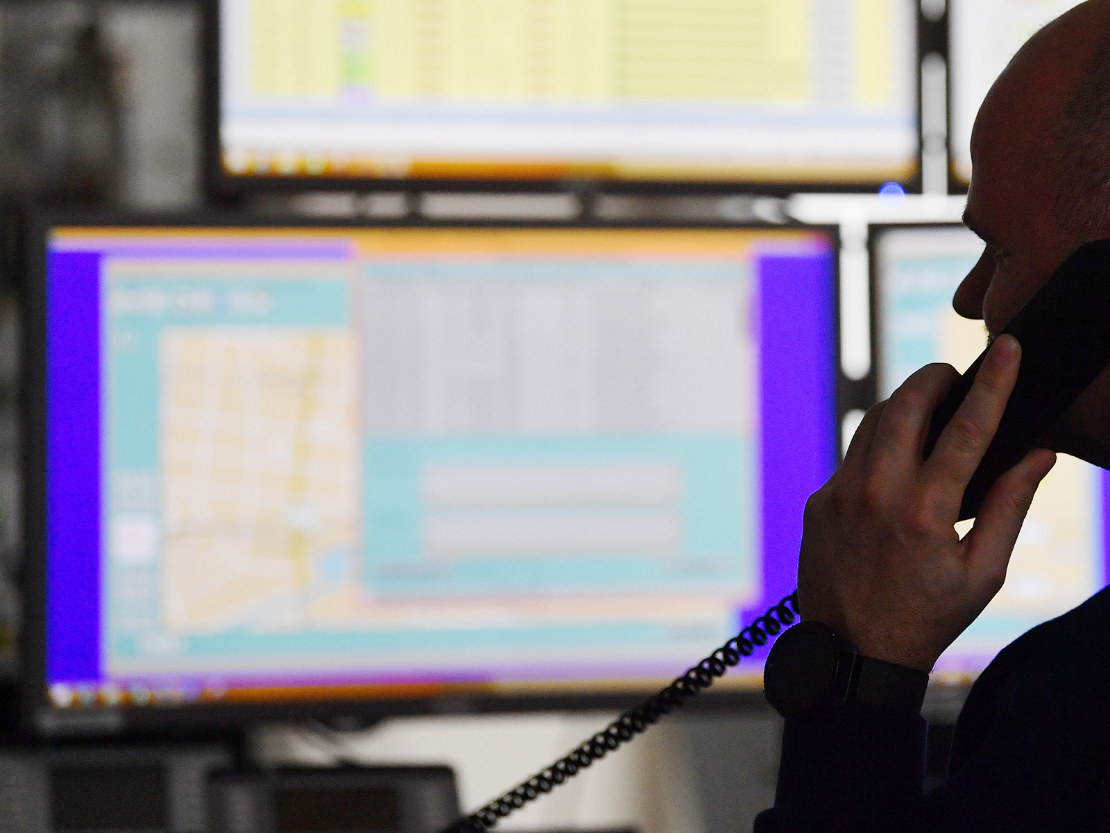 Mann am Telefon vor Monitoren in der BVG-Zentrale der Einsatzplanung