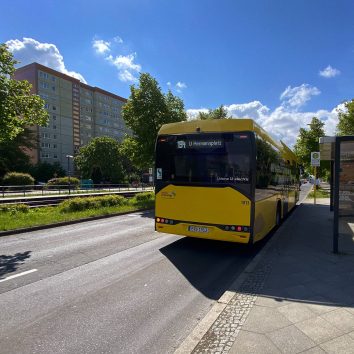 Ein Bus fährt gerade blinkend von einer Bushaltestelle ab.